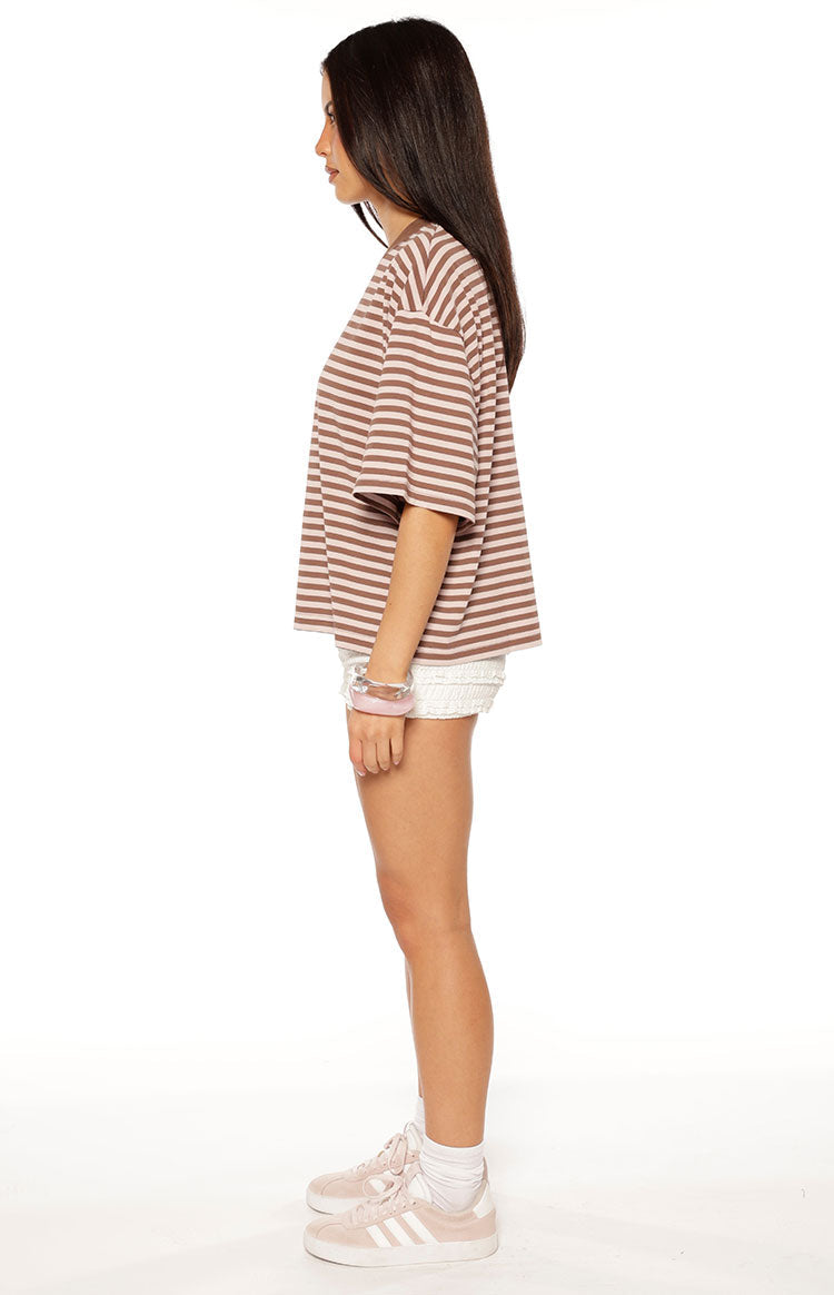 Woman in a brown and pink striped oversized cropped tee with white shorts a sweet and casual look for Spring