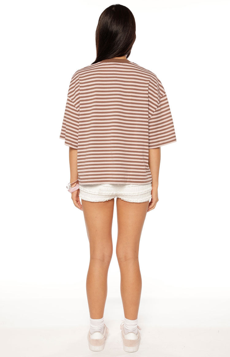 Woman in a brown and pink striped oversized cropped tee with white shorts a sweet and casual look for Spring