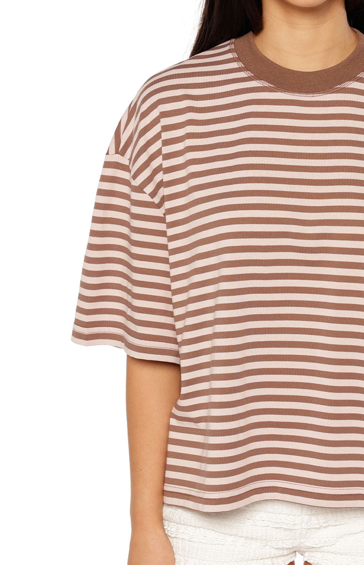 Woman in a brown and pink striped oversized cropped tee with white shorts a sweet and casual look for Spring