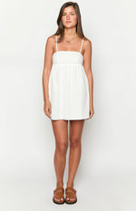 White mini dress with a straight neckline, thin spaghetti straps, a fitted bust, and a gathered A-line skirt