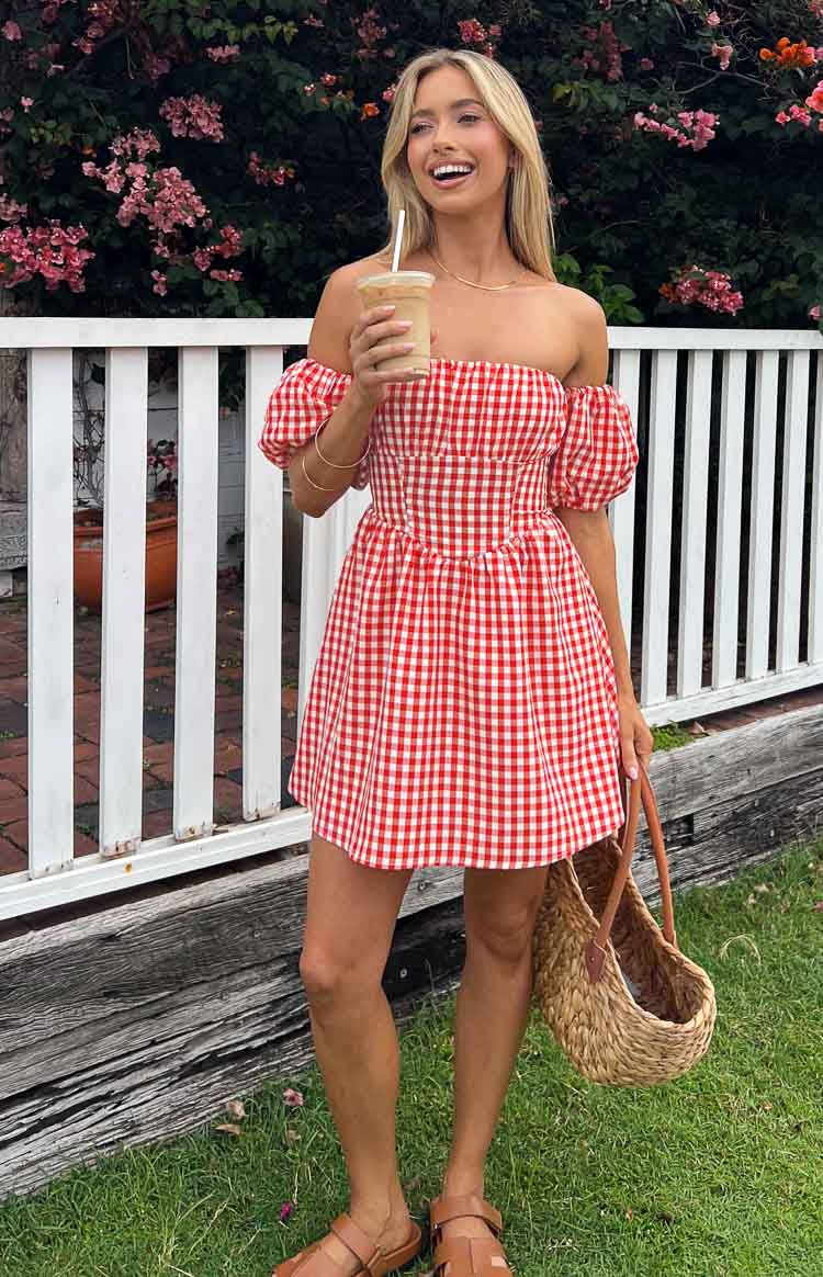Red and white gingham off-the-shoulder mini dress with puff sleeves, a corset-style bodice, and flared skirt