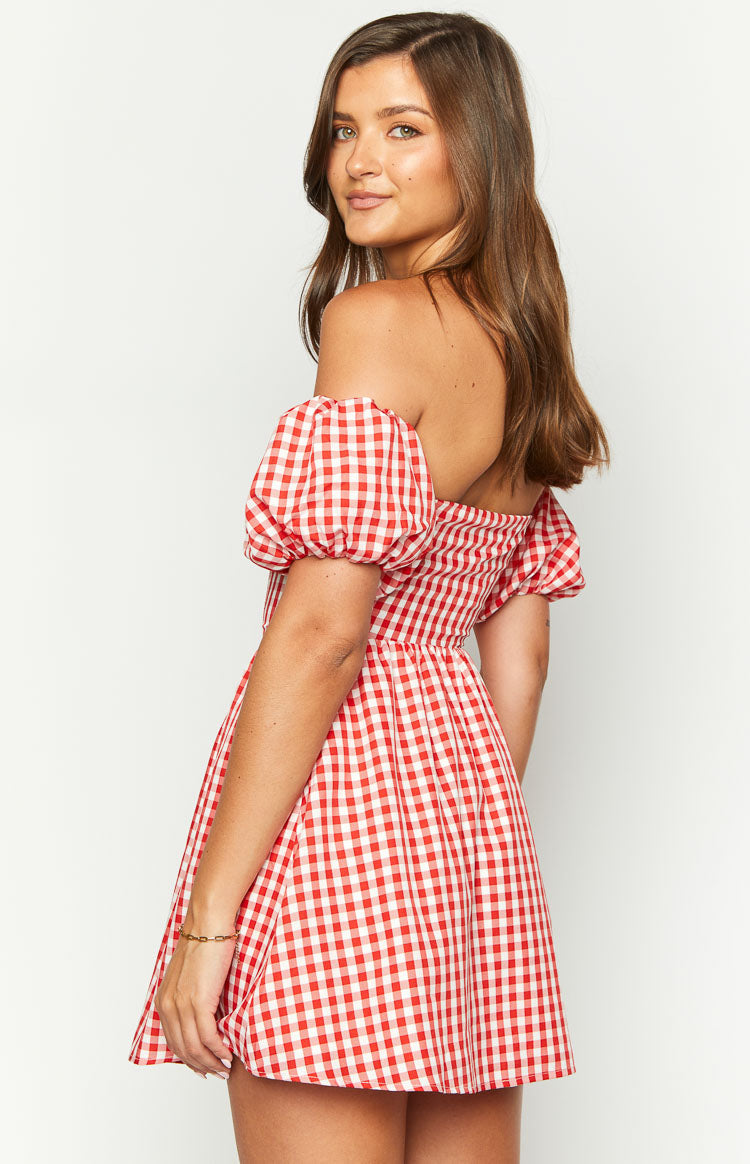 Side view showing the off-the-shoulder neckline, puffed sleeves, and shirred back of a red gingham mini dress