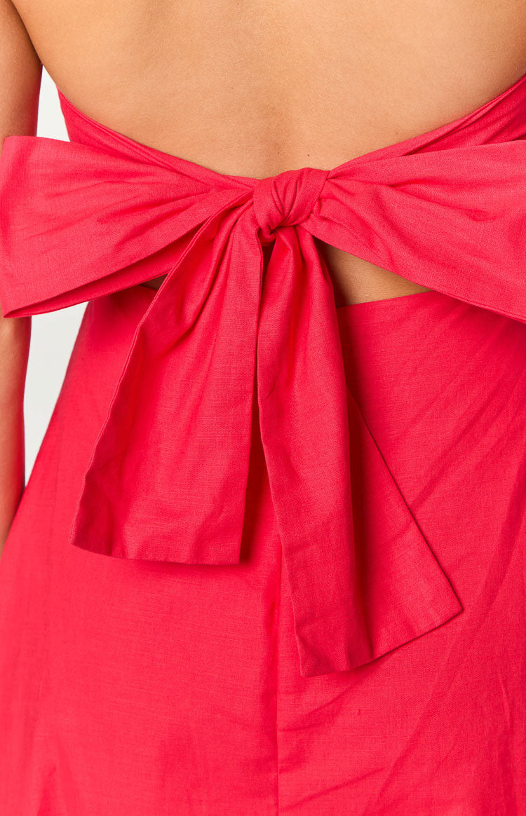 Close-up of the large red fabric bow tied at the back of the dress, with open waist cutouts