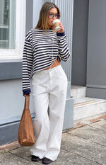 Full length view of white denim slouchy jeans with a relaxed wide leg and drawstring waist