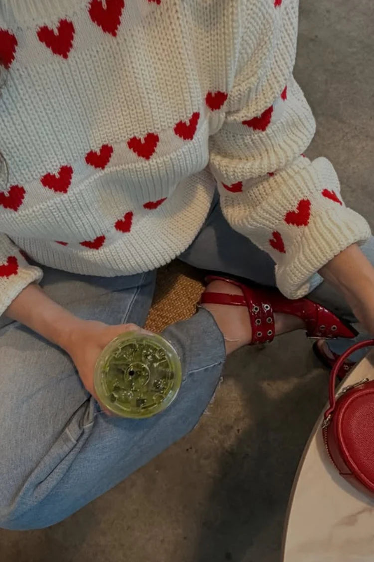 Crew neck white chunky knit jumper with red heart pattern on chest and sleeves
