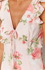 Close-up of the pink floral chiffon dress showing the tie-front V-neck, ruched bust, and ruffled cap sleeves
