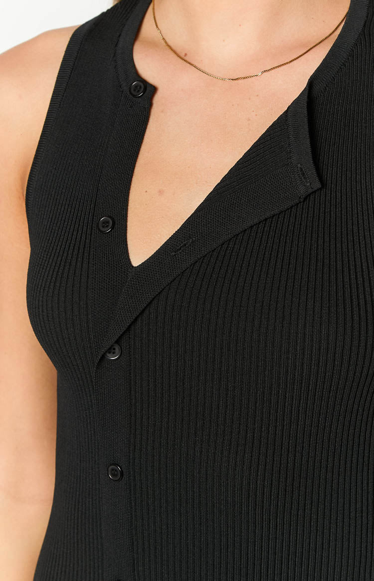 Close-up of the black ribbed knit fabric and the button-up V-neckline of the mini dress