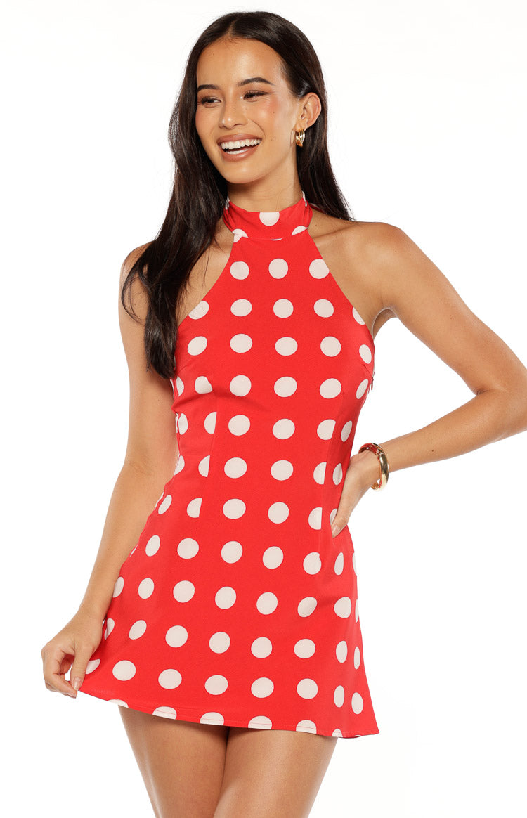 High halter neckline and fitted bodice of a red mini dress with white polka dots