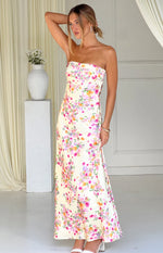 Side view of a yellow floral strapless maxi dress with pink and purple blooms and a flowy skirt