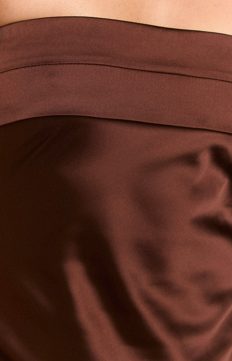 Close-up of the brown satin fabric with a visible seam detail on the maxi dress