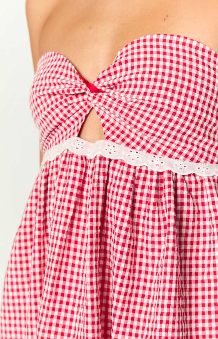Close-up of the red gingham dress showing the twisted knot bust, underbust cutout, and white eyelet lace trim