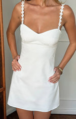 White mini dress with a sweetheart neckline and delicate daisy lace straps