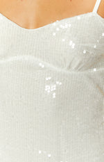Close-up of the white sequin fabric on the bust of the mini dress, showing the delicate mesh base and ruched detail