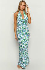Fitted white maxi dress with blue and green floral print, cowl neck halter, and waist ruching