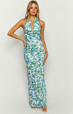 Fitted white maxi dress with a blue floral print, draped cowl halter neckline, and a straight skirt