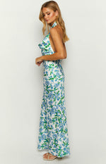 Side view of a white maxi dress with blue and green floral print, showing the halter neckline and low back
