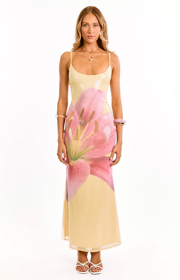 Front view of a yellow sequin maxi dress with a large pink lily floral print