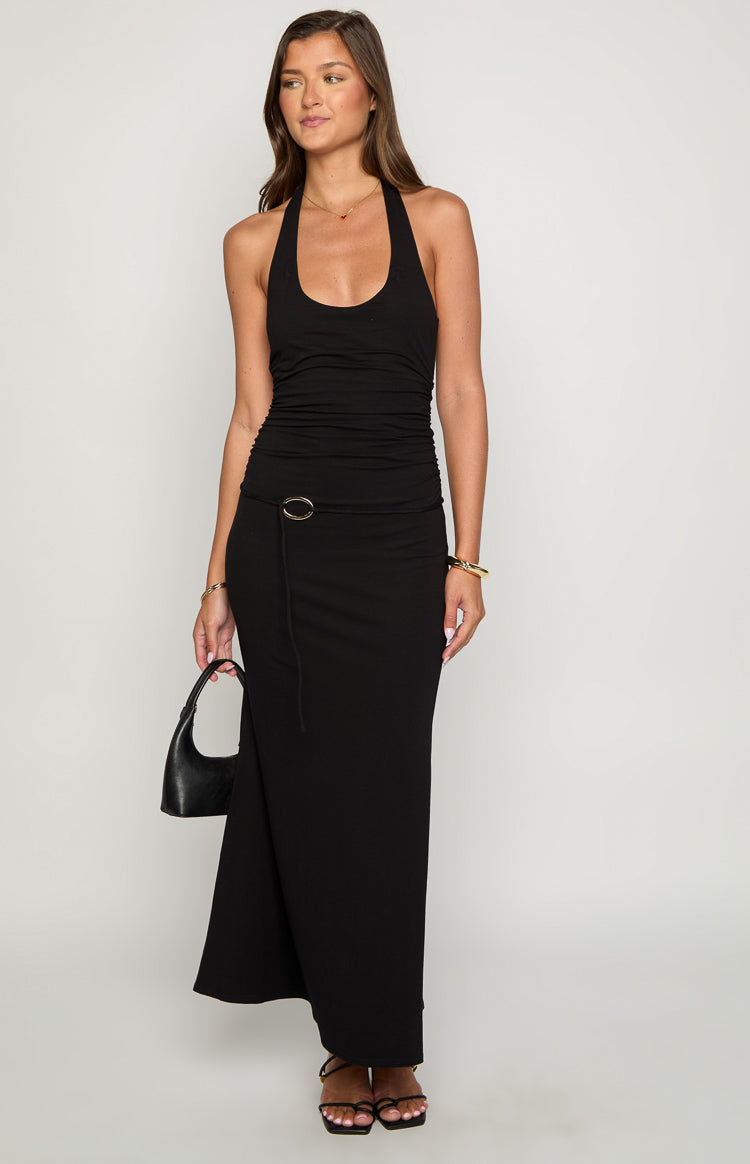 Front view of a black halter neck maxi dress with a ruched bodice and a gold O-ring detail with a tie at the waist