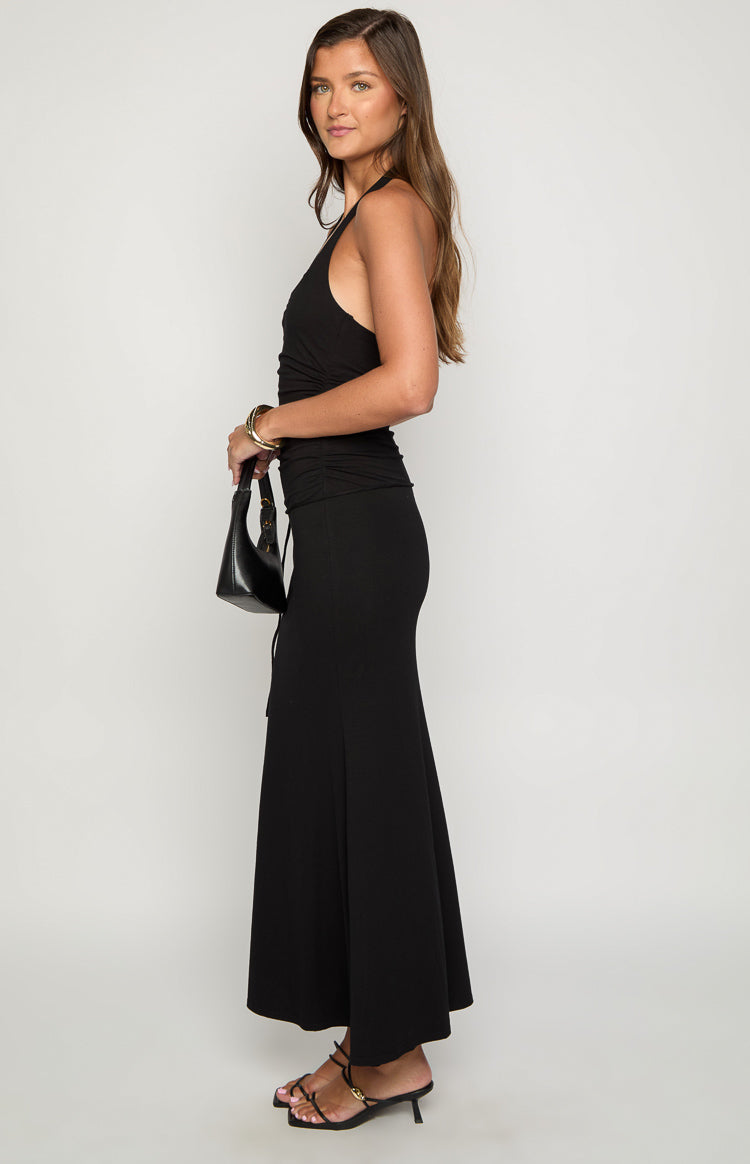 Side view of a black maxi dress with a ruched bodice and a flowing A-line skirt