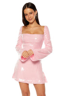 Our model wearing a light pink sequin mini-dress with a square neckline and long bell sleeves.