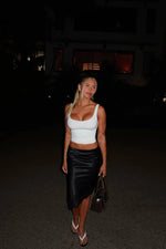Black satin midi skirt with a draped, flowy fit and an asymmetrical hemline