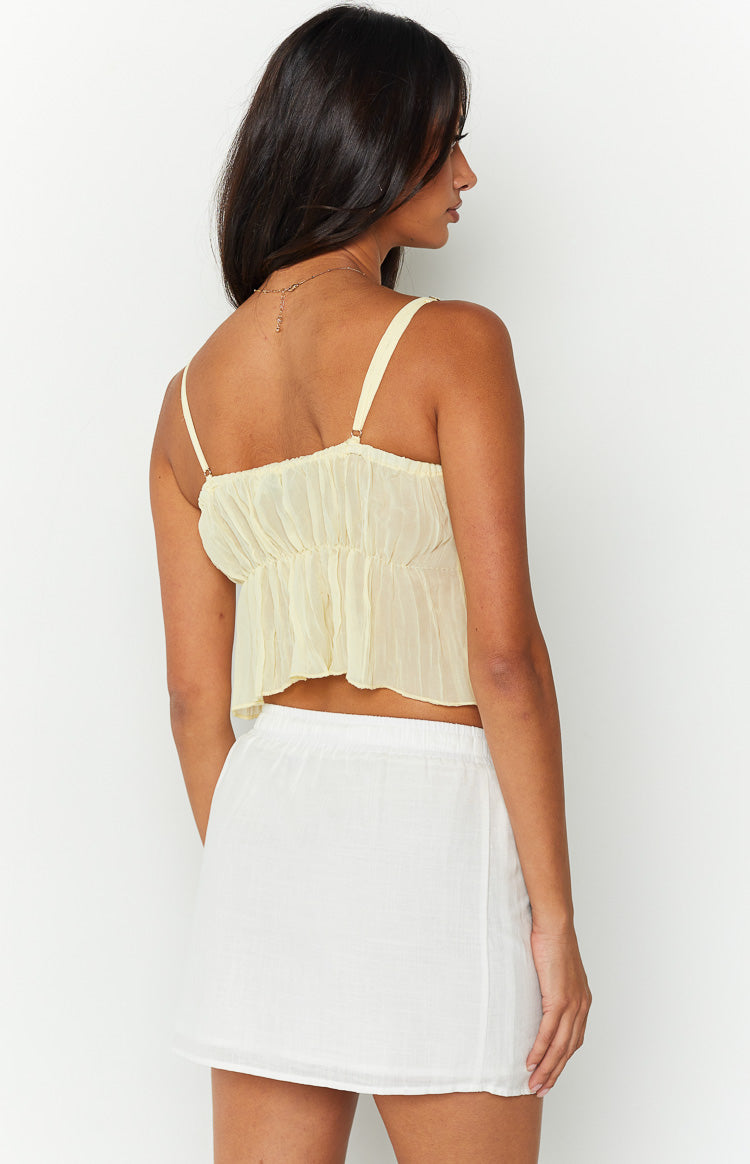Side and rear view of a white mini skirt with an elasticated waist and a subtle textured weave