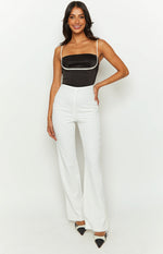 Front view of high-waisted white pants with a fitted silhouette through the hip and a flared leg