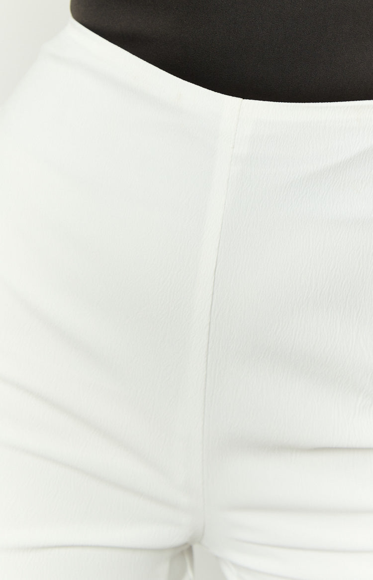Close-up of the white pants fabric with a subtle textured finish and a vertical seam