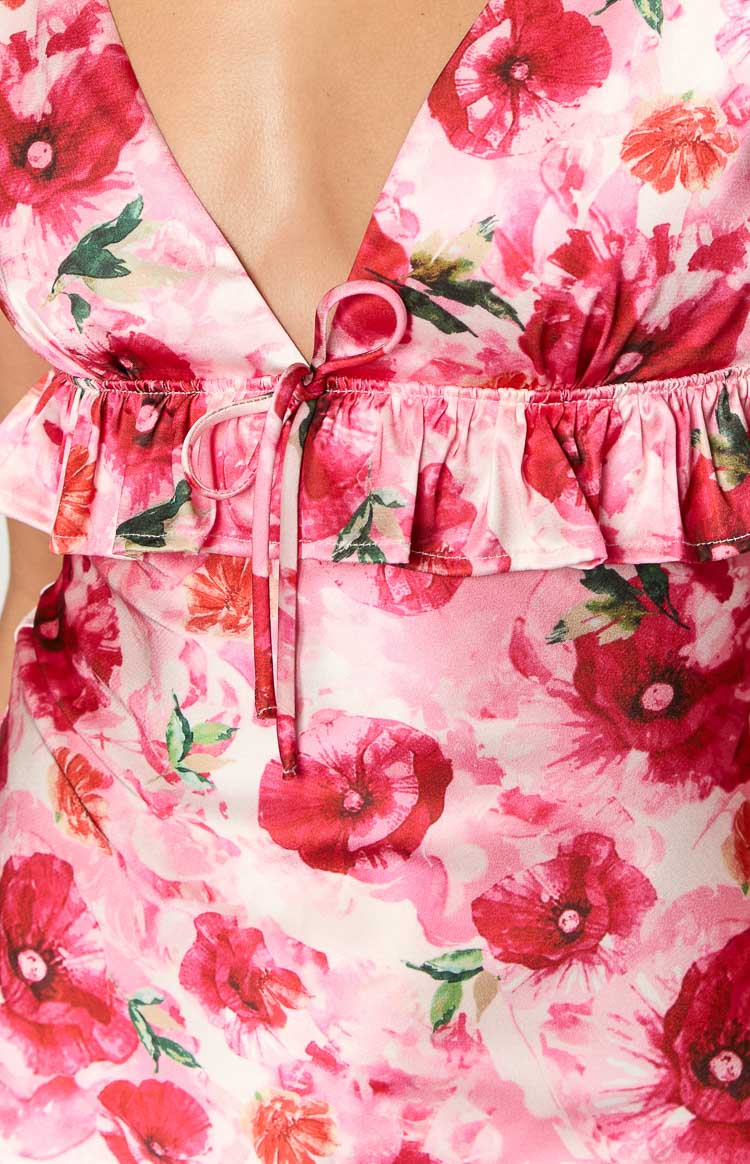 Close-up of the V-neckline with a tie-front detail and ruffled trim on a pink floral mini dress