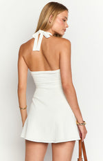Rear view of a white textured mini dress with a halter neck tie and open back