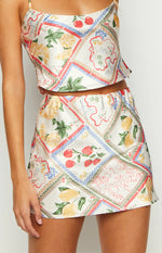Beginning Boutique Milliana White Satin Roma Print Skirt white satin mini skirt with patchwork fruit and floral print