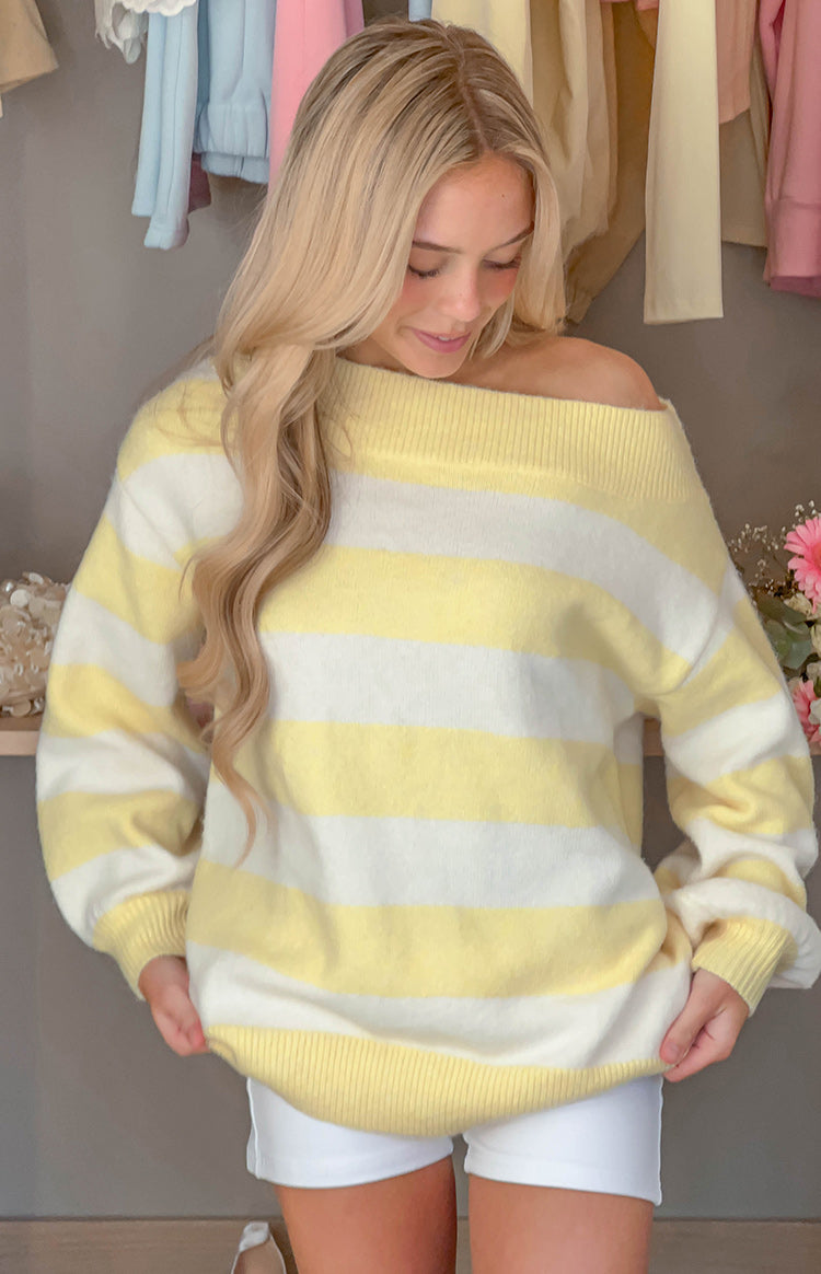 Close-up of the yellow and white striped off shoulder knit sweater with a ribbed neckline