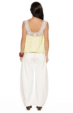 Rear view of the yellow satin top with white lace trim on the back neckline and straps, showing the gathered back