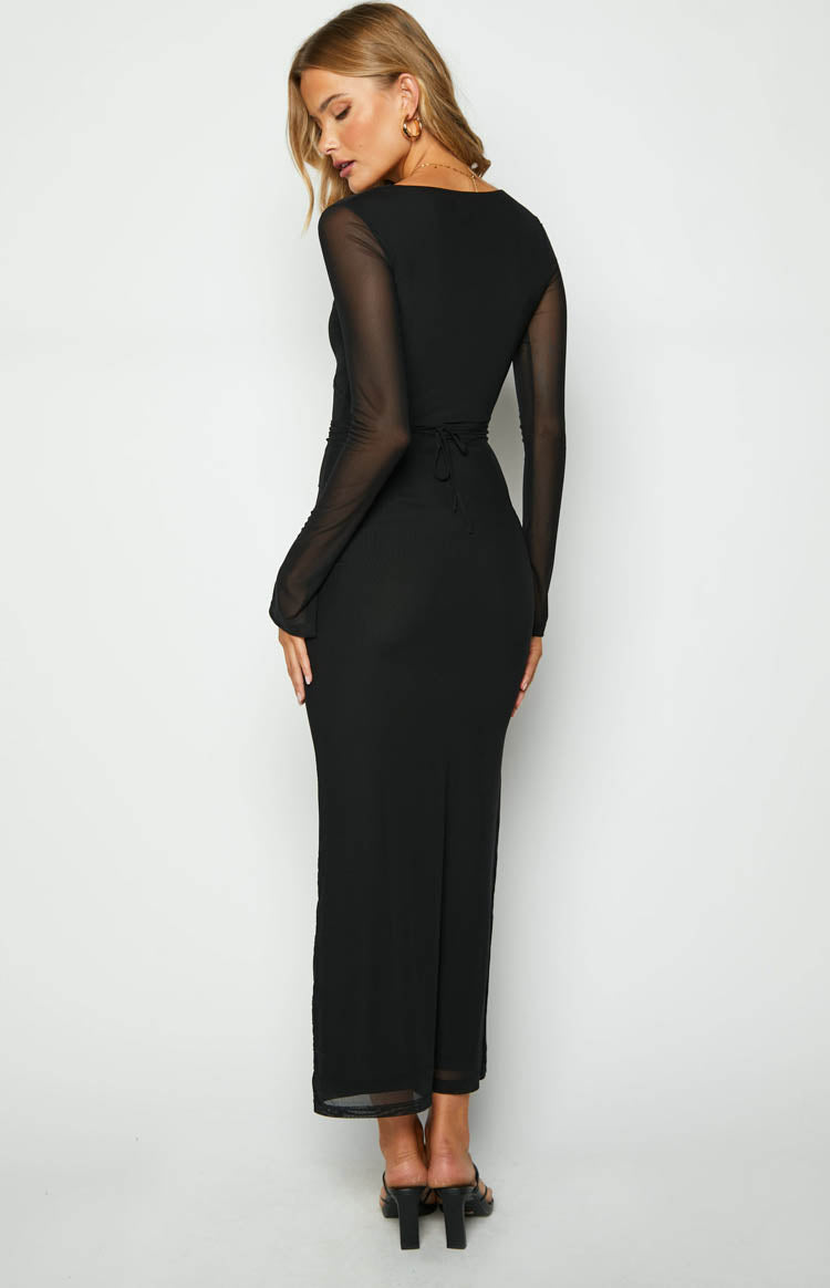 Close-up of the black maxi dress showing the deep V-neckline with criss-cross straps, wrapped waist, and sheer long sleeve
