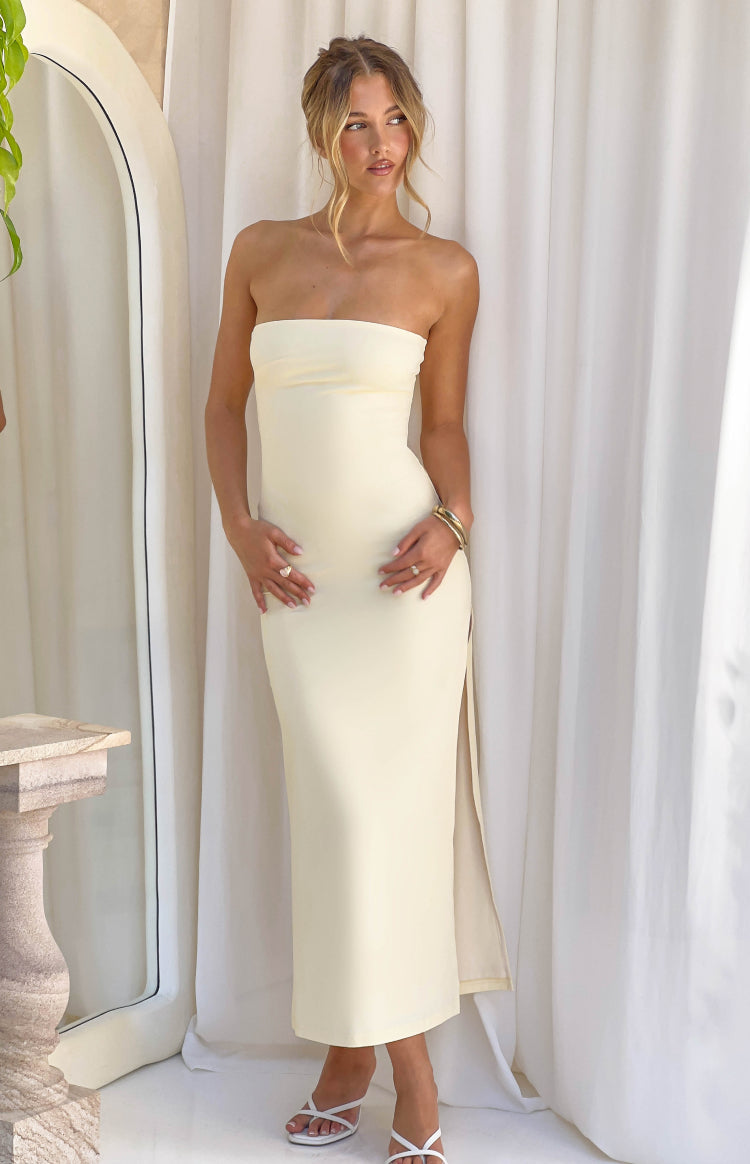 Front view of a pale yellow strapless bandeau top and matching high-waisted maxi skirt with a side split