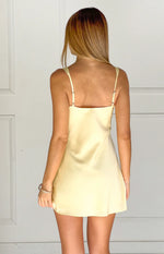 Rear view of a yellow satin mini dress with thin adjustable spaghetti straps and a straight back neckline