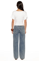 Rear view of a white jersey top with a boat neckline and short dolman sleeves, showing the ruched waist detail