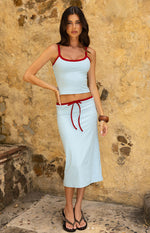 Front view of a light blue cropped tank top with red contrast trim on the scoop neckline and thin straps