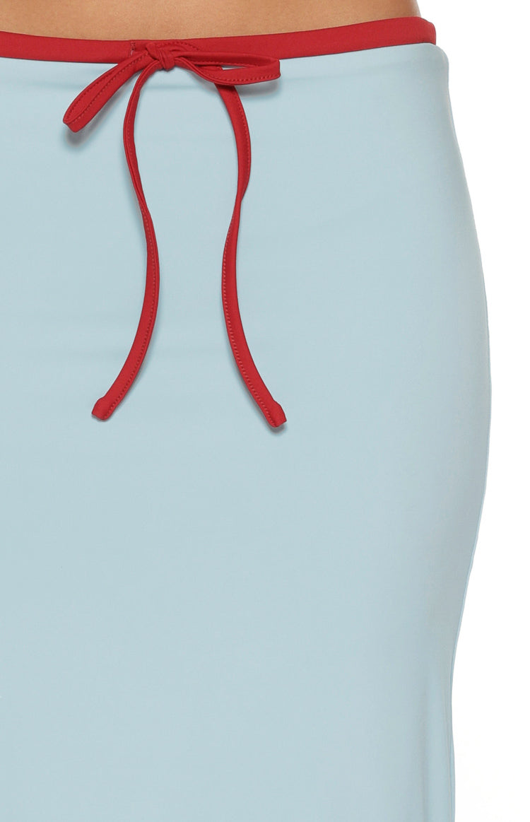 Close-up of the red tie waist detail and contrasting red waistband on the blue jersey midi skirt