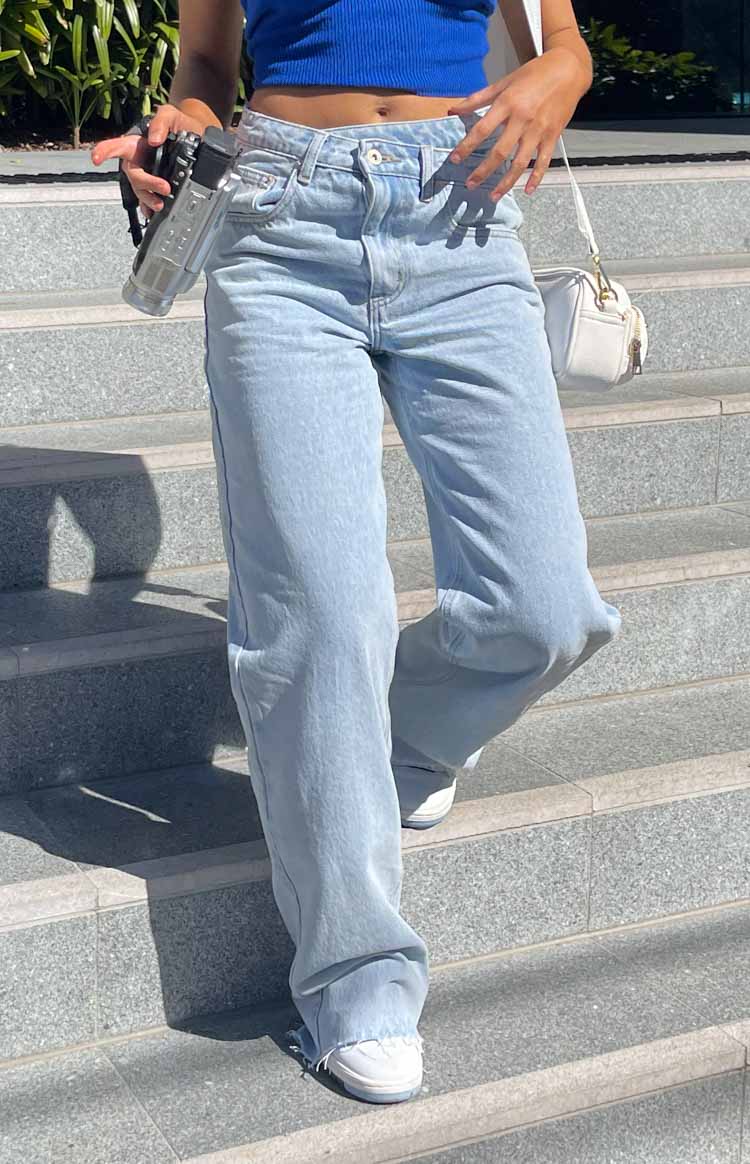 Front view of light blue wide-leg jeans with a relaxed fit and frayed raw hem