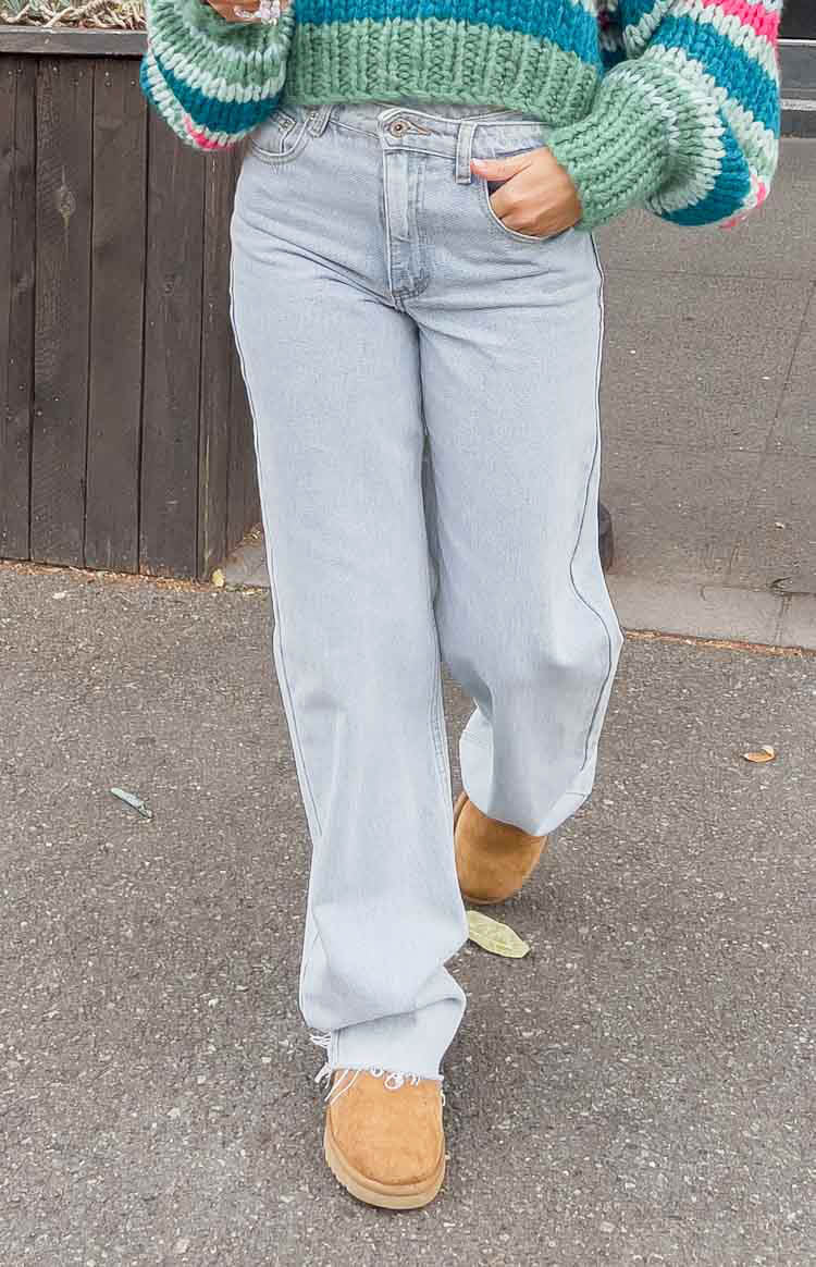 Light blue wide-leg jeans featuring an uneven waist and distressed frayed raw-cut hems