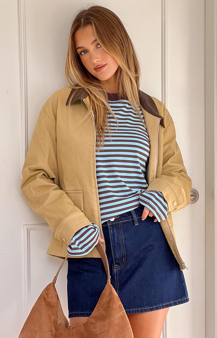 Front view of a cream canvas jacket with a brown contrast collar, open zipper, and front pockets