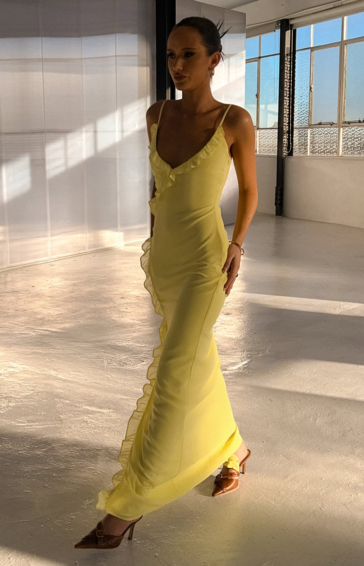 Side view of a yellow maxi dress showing thin spaghetti straps and a full-length ruffle detail