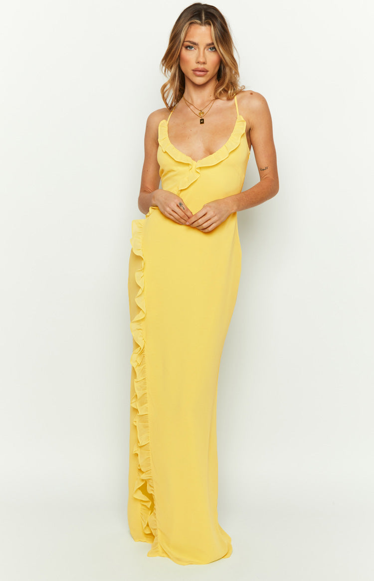 Yellow maxi dress with a ruffled V-neckline, thin straps, and a long ruffle detail down the side of the skirt
