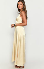 Side view of a pale yellow satin maxi dress showing the fluid drape of the skirt and criss-cross back straps