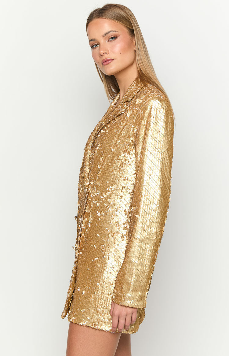 Side view of a gold sequin blazer mini dress, highlighting the structured lapel collar, long sleeves, and mini length