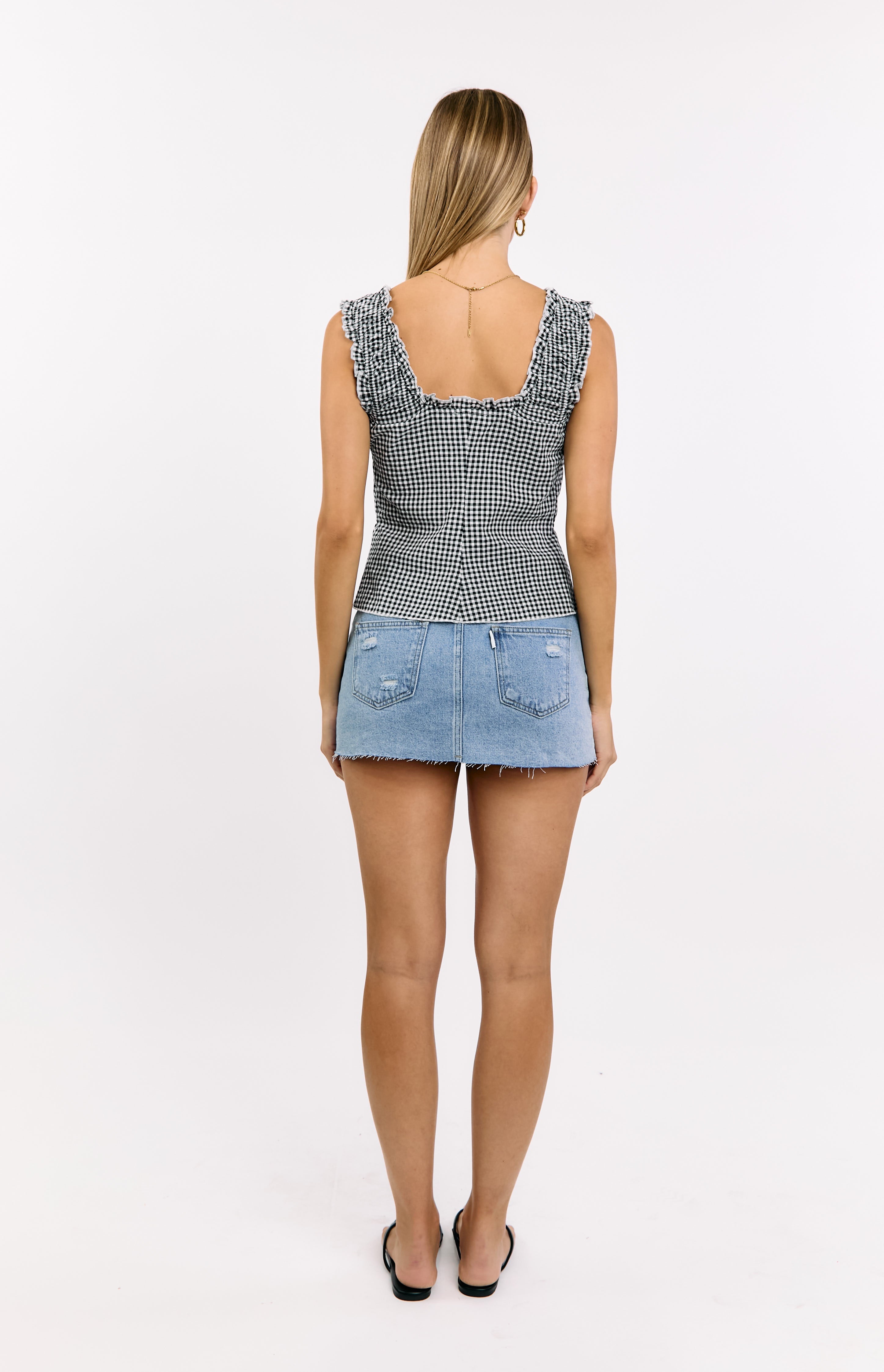 Rear view of a black gingham tie top with a square back neckline and ruffled cap sleeves