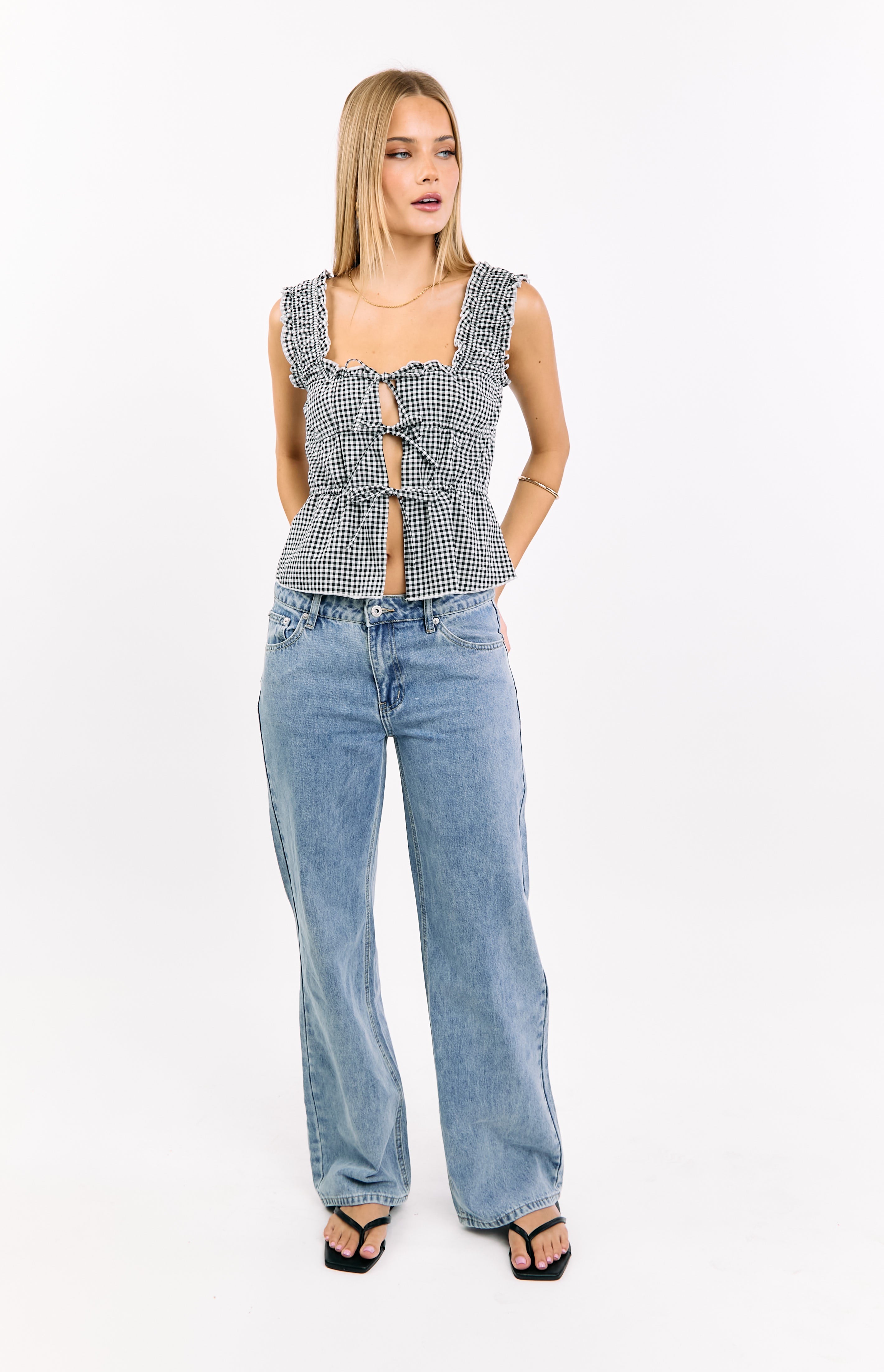 Black gingham crop top with a square neckline, ruffled straps, and multiple ties creating front cutouts