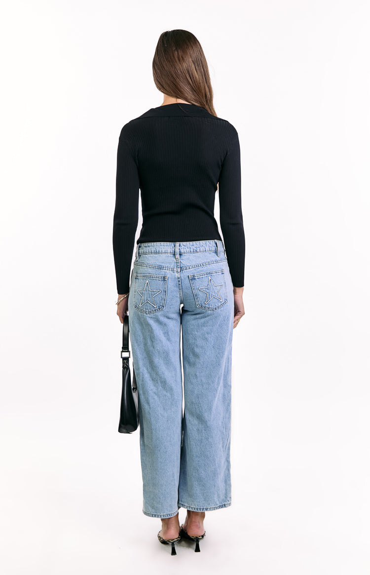 Rear view of a black ribbed knit long sleeve sweater with a collared neckline and fitted silhouette