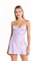 A sleeveless lavender mini-dress with a subtle floral jacquard pattern thin spaghetti straps and a sweetheart neckline with a lace trim.
